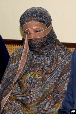 FILE - Pakistani Christian Asia Bibi listens to Punjab Gov. Salman Taseer, unseen, at a prison in Sheikhupura, near Lahore, Pakistan, Nov. 20, 2010.