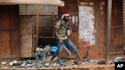 Un jeune milicien du groupe des anti-Balaka en train de piller un marché musulman le 22 janveir 22 2014 à Bangui, en République Centrafricaine.