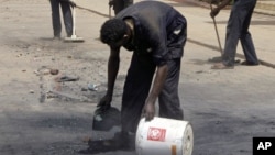 Workers outside the Qurtoba conference hall clean up debris after demonstrations by Sudanese university students and citizens yesterday in the capital Khartoum, Sudan, June 24, 2012.