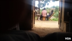 FDLR combatants playing cards with civilians in Lusoa village, North Kivu, DRC, March 28, 2015. (Nicholas Long for VOA News)