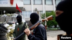 Armed pro-Russian rebels stand guard outside the town hall in Mariupol, eastern Ukraine, May 4, 2014.