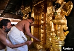 A priest closes the doors of sanctorum for performing religious rituals following the entry of two women in Sabarimala temple in Pathanamthitta, India, Jan. 2, 2019.