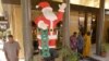 Des musulmans assistent à la prière du vendredi après-midi à côté d'un Père Noël gonflable près d’une boulangerie dans le centre de Dakar, au Sénégal, 16 décembre 2005.