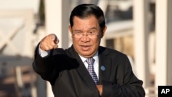 រូបឯកសារ៖ លោក​នាយក​រដ្ឋមន្ត្រី ហ៊ុន​ សែន លើក​ដៃ​ចង្អុល ខណៈពេល​ដែល​លោក​ត្រៀម​ថតរូប​រួម​គ្នា​ជាមួយ​នឹង​មេដឹកនាំ​ប្រទេស​ផ្សេងៗ ដែល​ចូលរួម​កិច្ច​ប្រជុំអាស៊ីអ៊ឺរ៉ុប​លើក​ទី១១ នៅ​ទីក្រុងអ៊ូឡង់បាទ័រ ប្រទេស​ម៉ុងហ្គោលី កាលពីថ្ងៃសៅរ៍ ទី១៦ ខែកក្កដា ឆ្នាំ២០១៦។ (AP)