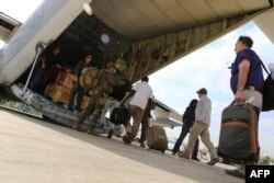 FILE - Marines and sailors with Special Purpose Marine Air-Ground Task Force help U.S. citizens into a Marine Corps airplane in Juba during an evacuation of personnel from the U.S. Embassy, Jan. 3, 2014.