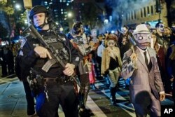 Teško naorižan policajac stražari tokom Grinvič vilidž Helovin parade u Njujorku, 31. oktobra 2017.