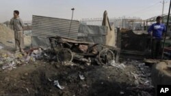 Afghan boys stand at the scene where a rocket landed in Kabul, Afghanistan, November 17, 2011.