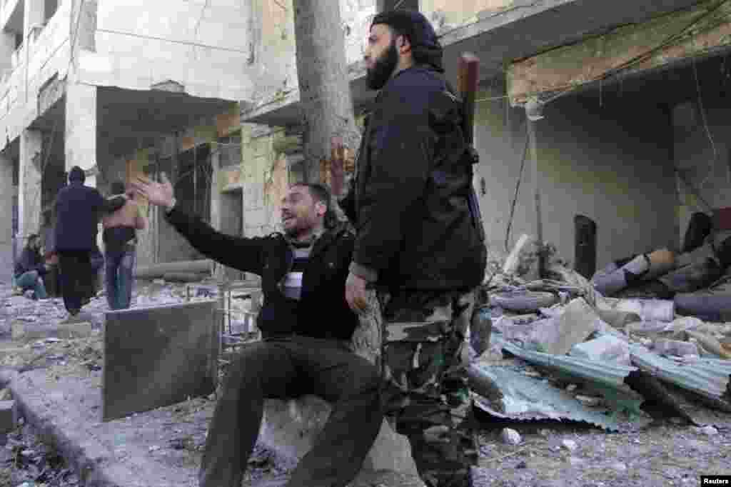A man reacts at the site of what activists said was an air raid by forces loyal to Syrian President Bashar Al-Assad in the al-Marja district of Aleppo, Dec. 23, 2013. 