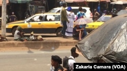 Un albinos mendie sur une avenue à Conakry, Guinée, 22 avril 2017. (VOA/Zakaria Camara)