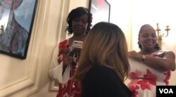 Miami Herald journalist, Haitian-American Jacqueline Charles,(far left) posts updates to her Twitter feed from the Embassy of Haiti's iconic winding staircase, Oct. 7, 2018. (Photo: S. Lemaire / VOA)