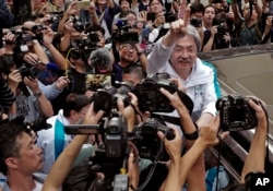 FILE - Chief Executive candidate, Hong Kong's former Financial Secretary John Tsang, center, waves to supporters at an election campaign in Hong Kong, March 24, 2017.