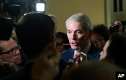 Reporters gather around Sen. Rob Portman, R-Ohio, on Capitol Hill in Washington, Dec. 15, 2017.