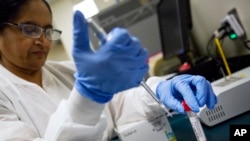 FILE - A lab technologist tests a patient's swab for a flu infection at Upson Regional Medical Center in Thomaston, Ga., Feb. 9, 2018.