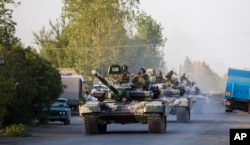 FILE - Azerbaijan tanks move toward Agdam, Azerbaijan, following days of escalated fighting between Azerbaijani and Armenian forces over a tense line of control around Nagorno-Karabakh, Aug. 2, 2014.