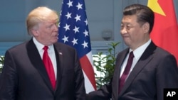FILE - U.S. President Donald Trump and Chinese President Xi Jinping arrive for a meeting on the sidelines of the G-20 Summit in Hamburg, Germany.