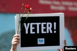 FILE - A member of the Journalists Union of Turkey (TGS) holds a placard reading "Enough!" during a demonstration to mark World Press Freedom Day in central Istanbul, Turkey, May 3, 2017. Lack of freedom of speech is among EU concerns Turkey faces as it tries to revive its efforts to join the bloc.