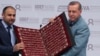 Turkey’s President Recep Tayyip Erdogan (R) receives a copy of the Quran, Islam's holy book, at an international students meeting in Istanbul May 16, 2015.