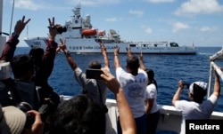 FILE - A Chinese Coast Guard vessel maneuvers to block a Philippine government supply ship with members of the media aboard at the disputed Second Thomas Shoal, part of the Spratly Islands, in the South China Sea.