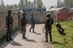 Indian paramilitary soldiers stand guard outside a school where a principal and a teacher were shot dead by assailants, in Srinagar, Indian-controlled Kashmir, Oct. 7, 2021.