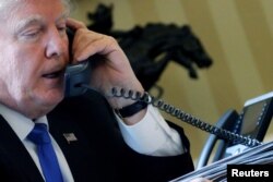 FILE - U.S. President Donald Trump speaks by phone with Russia's President Vladimir Putin in the Oval Office at the White House in Washington, Jan. 28, 2017.