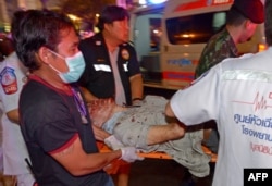 Thai rescue workers transport an injured person after a bomb exploded outside a religious shrine in central Bangkok late on Aug. 17, 2015 killing at least 10 people and wounding scores more.