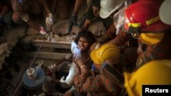 FILE - Rescue workers pull a garment worker from the rubble of a collapsed building outside of Dhaka April 27, 2013.
