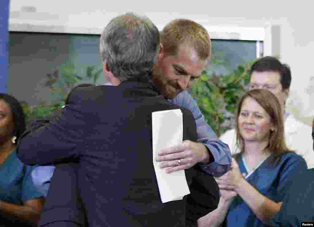 Kevin Brantly, who contracted the deadly Ebola virus, hugs a member of Emory's medical staff during a press conference at Emory University Hospital in Atlanta, Georgia, Aug. 21, 2014.