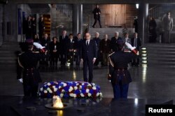 French President Francois Hollande (C) pays his respects after he placed a wreath at the Shoah memorial in Paris, Jan. 27, 2015.