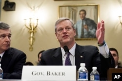 North Carolina Gov. Roy Cooper, left, watches as Massachusetts Gov. Charlie Baker speaks while they testify before the House Natural Resources Committee hearing on climate change, on Capitol Hill in Washington.