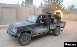 FILE - Members of the Libyan internationally recognized government forces fire during fighting with Eastern forces in Ain Zara in Tripoli, Libya, April 20, 2019.