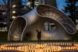 Seorang pengunjung mengambil gambar lentera kertas di "taman lilin Washi", dalam peringatan 10 tahun tsunami dan bencana nuklir di distrik Roppongi Tokyo, 11 Maret 2021.