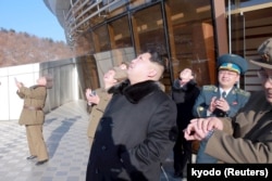 North Korean leader Kim Jong Un, center, watches a long range rocket launch into the air in North Korea, in this photo released by Kyodo, Feb. 7, 2016.