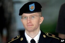 FILE - Army Pvt. Chelsea Manning, then-Army Pfc. Bradley Manning, is escorted out of a courthouse in Fort Meade, Maryland, after the third day of his court martial, June 5, 2013.