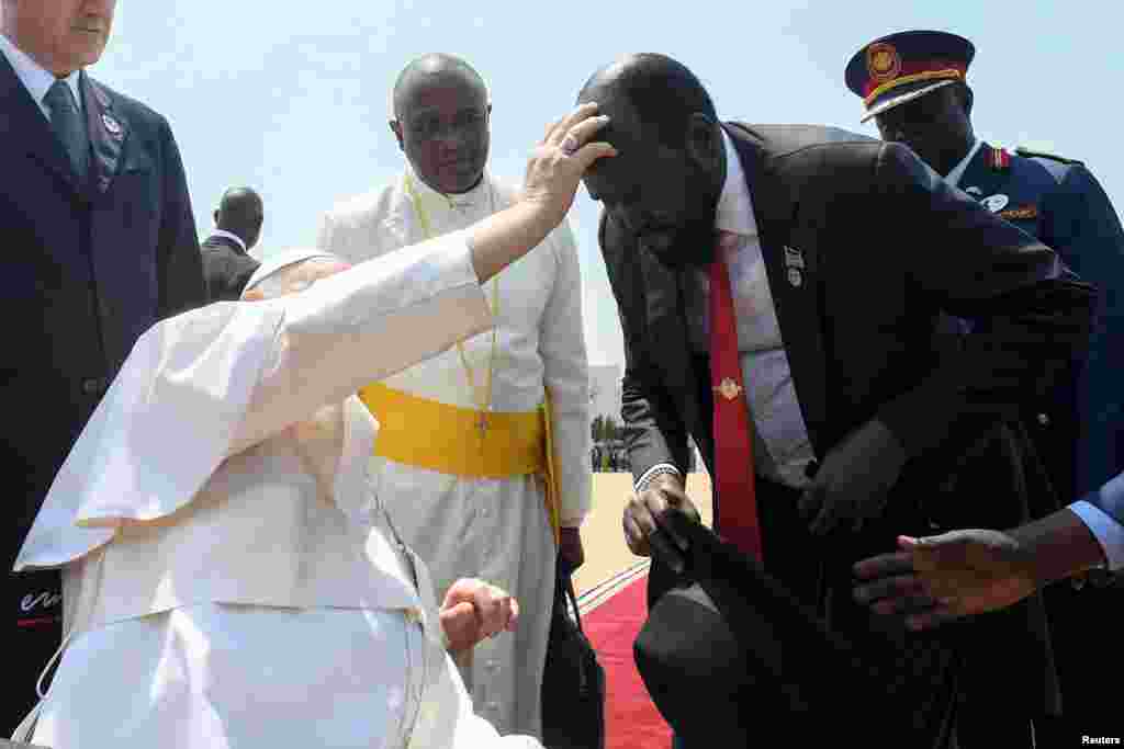 Papa Francis akimuombea Rais Salva kiir wa Sudan Kusini wakati wa sherehe za kumuaga kabla ya kuondoka Juba, Sudan Kuisni 