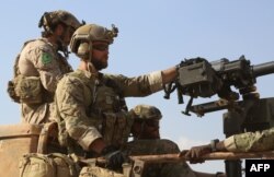 Syria -- Armed men in uniform identified by Syrian Democratic forces as US special operations forces ride in the back of a pickup truck in the village of Fatisah in the northern Syrian province of Raqa, May 25, 2016