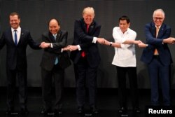 U.S. President Donald Trump smiles with other leaders, including Russia's Prime Minister Dmitry Medvedev, Vietnam's Prime Minister Nguyen Xuan Phuc, President of the Philippines Rodrigo Duterte and Australia's Prime Minister Malcolm Turnbull, as they cr
