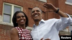 Presiden Obama dan ibu negara Michelle Obama dalam kampanye di Dubuque, Iowa (15/8).