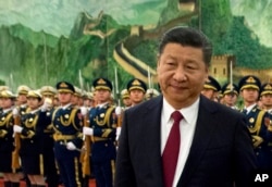 FILE - In this Tuesday, Jan. 9, 2018, file photo, Chinese President Xi Jinping reviews a Chinese honor guard during a welcome ceremony for a visiting dignitary at the Great Hall of the People in Beijing.