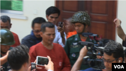 Meach Sovannara, CNRP senior activist, escorted by prison guards to the appeal room.