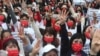 Myanmar nationals living in Taiwan make the three-finger salute of resistance as they attend a protest against the military regime in Myanmar during a demonstration at Liberty Square in Taipei, Taiwan, March 21, 2021. 