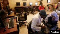 FILE - People sit in an internet cafe in Cairo, Feb. 3, 2008.