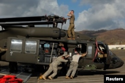 Soldiers with the U.S. Army's 1st Armored Division, Combat Aviation Brigade, work to unload a UH-60 Blackhawk helicopter from a U.S. Air Force C-5 Galaxy to aid in recovery efforts following Hurricane Maria, Puerto Rico, Oct. 4, 2017.