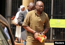 Pastor Evan Mawarire is escorted by detectives as he arrives at court to face charges of attempting to subvert the government, in Harare, Zimbabwe, Sept. 26, 2017.