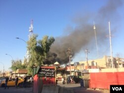 A blaze in a Kurdistan political party office in Kirkuk, Iraq draws onlookers who video the scene on their mobile phones on Oct. 17, 2017. (H.Murdock/VOA)