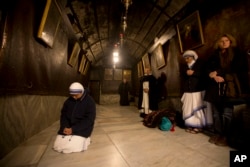 A nun prays inside the Grotto at the Church of the Nativity, traditionally believed by Christians to be the birthplace of Jesus Christ, in the West Bank city of Bethlehem on Christmas Eve, Dec. 24, 2015.