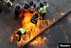 Riot security forces members catch fire during riots at a rally against Venezuelan President Nicolas Maduro's government in Caracas, Venezuela, June 7, 2017.