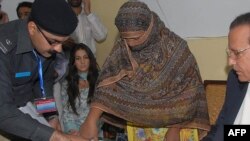 FILE - In this Nov. 20, 2010, file photo, Asia Bibi, a Pakistani Christian woman, listens to officials at a prison in Sheikhupura near Lahore.