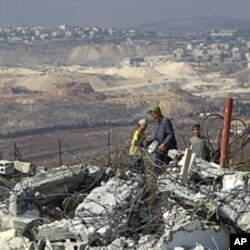 Jewish settler boys stand atop ruins of razed buildings in the unauthorized Jewish hilltop outpost of Migron, near the West Bank city of Ramallah, September 5, 2011.