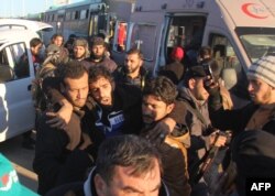 A wounded Syrian, who was evacuated from rebel-held neighborhoods in the embattled city of Aleppo, is carried upon his arrival in the opposition-controlled Khan al-Aassal region, west of the city, on Dec. 15, 2016.