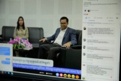 Facebook users comment during a VOD Roundtable show on judicial corruption in Cambodia with host Lim Thida, left, and one of her guests, Justice Ministry spokesman Chin Malin, VOD's studio, in Phnom Penh, Sept. 11, 2019. (Tum Malis/VOA Khmer)